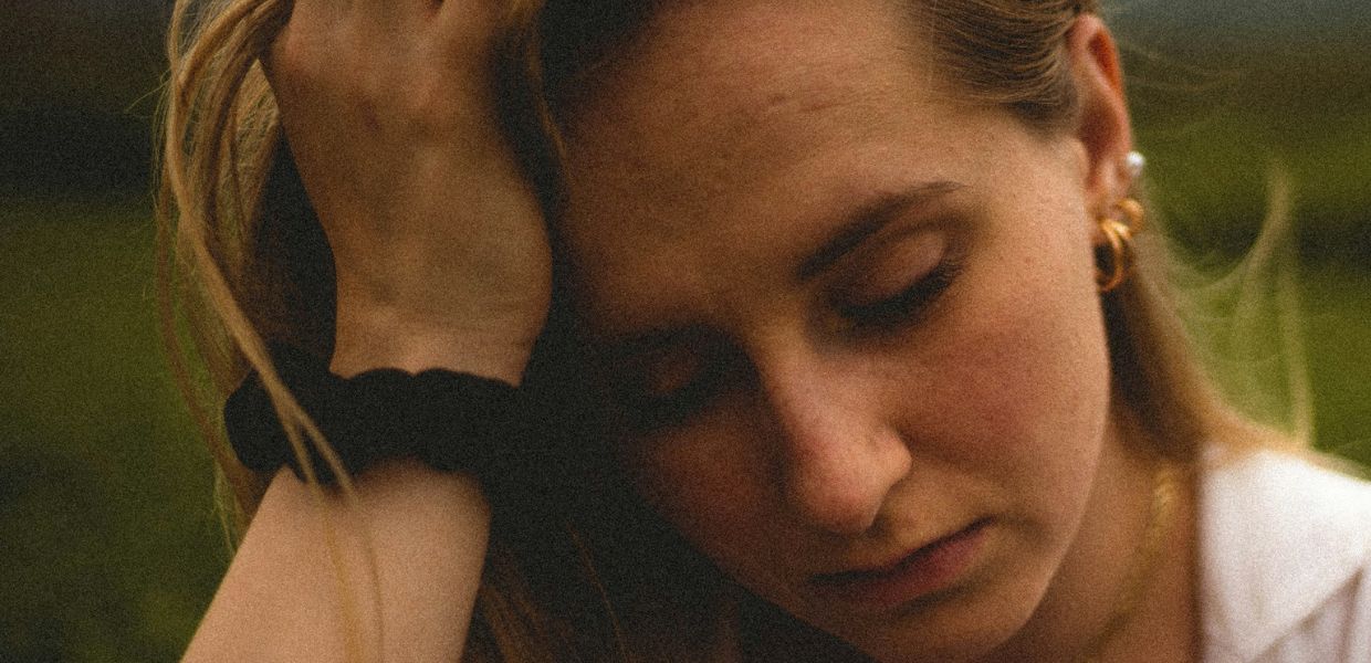Woman holding her head in her hand